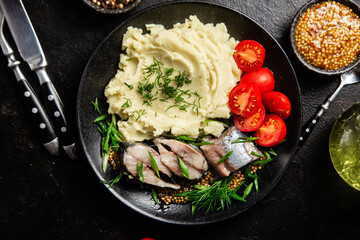 Herring with mashed potatoes tomatoes and mustard on a plate