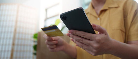 Online Shopping. Woman holding smartphone and credit card for digital purchases.
