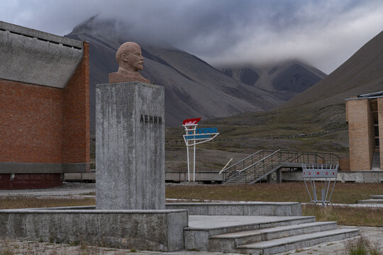 View of Lenin's bust stands stark against the ghostly backdrop of mountains and cloudy skies in the abandoned town, Pyramiden, Svalbard and Jan Mayen.
