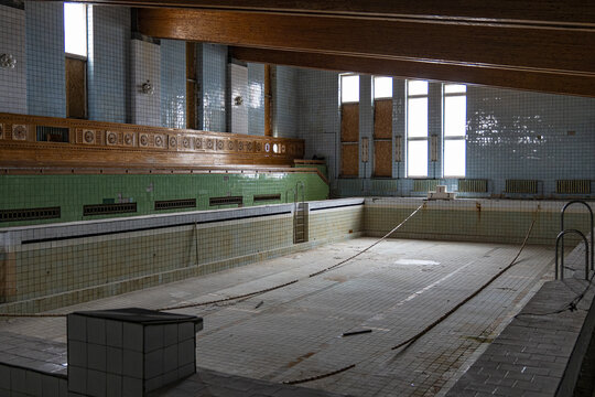 View of a drained swimming pool with faded tiles and wooden accents, a silent testament to a bygone era in Pyramiden, Svalbard and Jan Mayen.