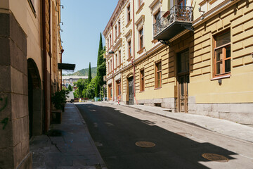 Charming street in a historic district with sunshine illuminating the buildings and empty pathways...