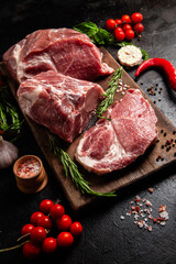 Raw Pork Cuts with Herbs and Spices on a Wooden Board