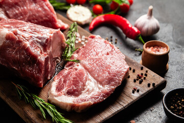 Raw Pork Cuts with Herbs and Spices on a Wooden Board