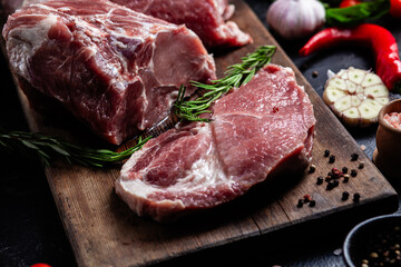 Raw Pork Cuts with Herbs and Spices on a Wooden Board