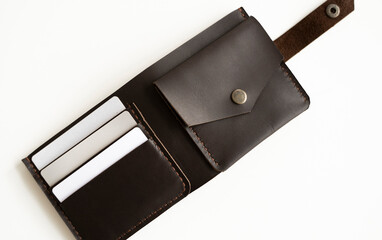 Opened handmade brown leather wallet with a blank cards inside on marble surface