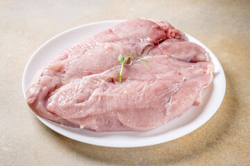 Raw turkey breast fillet on white plate