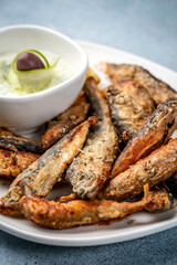 Closeup of fried sardines with tzatziki