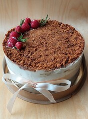Homemade birthday cake decorated with berries and tied with ribbon
