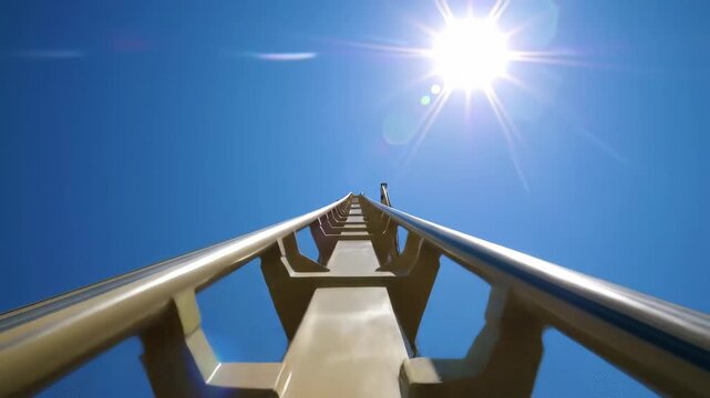 Rollercoaster ascent, sunny day, blue sky, amusement park