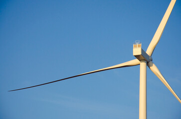 Fototapeta premium Renewable energy. Wind power plant in autumn field during sunrise.Building wind turbines. Wind turbine base.