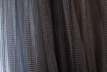 Textured mesh curtain background with soft folds and light transparency. Minimalist fabric texture for design, interior, and abstract concepts