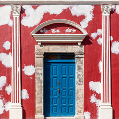 Red and white colonial facade architecture in restauration, Campeche city, Mexico.
