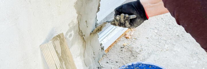 A weathered hand meticulously applies plaster, embodying the spirit of Labor Day's unyielding...