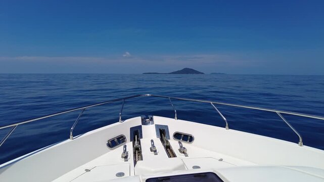 A white luxury yacht sails across the blue sea. A beautiful white motor vessel in motion, empty of people.