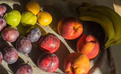 Ripe, Bright Peaches and Plums on the Table