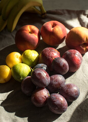 Ripe, Bright Peaches and Plums on the Table