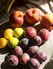 Ripe, Bright Peaches and Plums on the Table