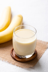 Banana milk in glass with banana fruit on white background