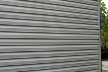 Bardage lame composite blanc gris sur la façade de la maison