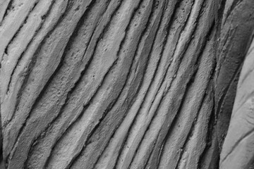 Rippled rock surface with wave-like patterns and soft curves.