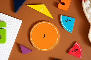 educational setup with colorful numbers, fraction pieces, on a brown surface. Bright blocks and learning tools encourage math fun and creativity for kids.