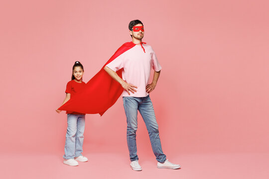 Full body young happy cool fun parent man child girl wear red casual clothes super hero coat mask Daddy little kid daughter isolated on plain pastel pink background Father's Day Love family concept - Powered by Adobe
