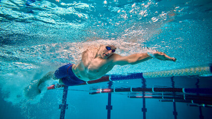 Underwater action shot of freestyle swimmer with intensity and focus. Concept of fitness promotion,...