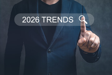 Businessman pointing at 2026 TRENDS search bar on virtual screen, a concept for new year's business and marketing analysis