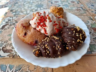 chocolate chip muffinplate of freshly baked buns sits on a beautifully patterned tiled table in a charming countryside setting. The colorful ceramic tiles add a touch of folk artistry, while the warm.