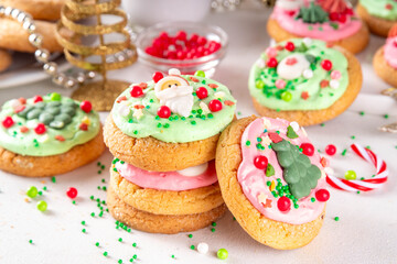 Festive Christmas decorated crumble cookies. Tasty american crumbl cookies copycat with green and red whipped cream frosting and Christmas sugar decorations on top, copy space