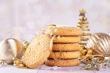 Stack of traditional american sugar cookies on Christmas background, with golden baubles, Christmas tree and bokeh effect, copy space