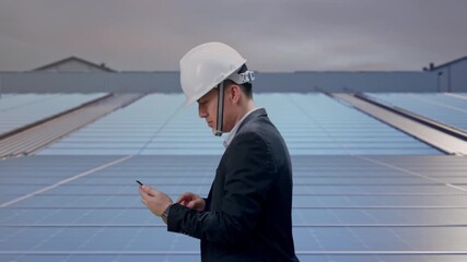 Side View of Asian Businessman Use Smartphone While Walking at Industrial Rooftop Solar Panels - Powered by Adobe