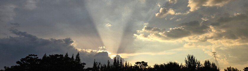 Panoramic view of sunset clouds and sun rays