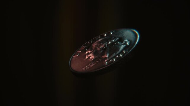 Seamless loop of a United States quarter dollar coin flipping on a dark background, symbolizing gambling, luck, finance, and decision making.