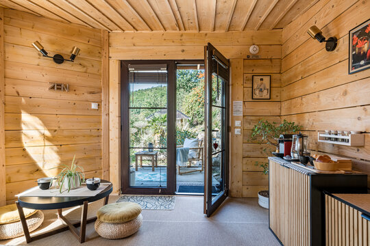 int&eacute;rieur zen de cabane japonaise avec baie vitr&eacute;e ouverte sur le jardin