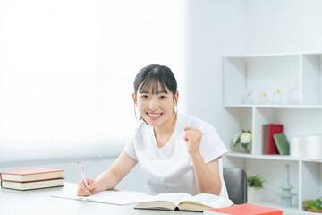 部屋で勉強する10代女性
