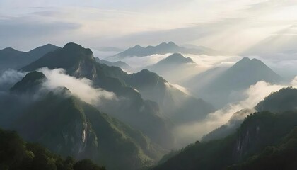 雲に覆われた緑の山々が太陽の光を浴びる