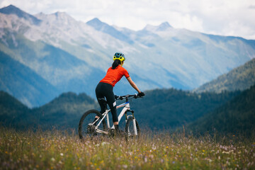 Fototapeta premium Woman riding mountain bike in the beautiful mountains