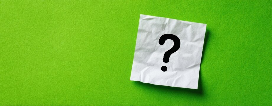 The Question Mark on a Crumpled Paper Note Over Vibrant Green Background