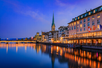 Naklejka premium Cityscape with the iconic Fraumunster church and classic buildings on the banks of the Limmat River in the Altstadt or Old Town in Zurich, Switzerland