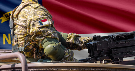 Fototapeta premium North Carolina US state flag with soldier at machinegun turret