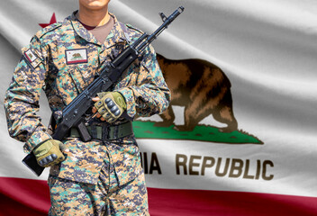 Fototapeta premium California US state flag with soldier holding assault rifle