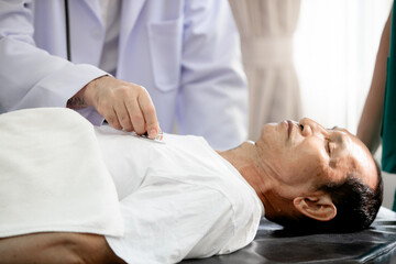 Close up of Doctor using stethoscope putting beat heart checking heart rate of senior man, check-up body, Medical and Health Care Concept.