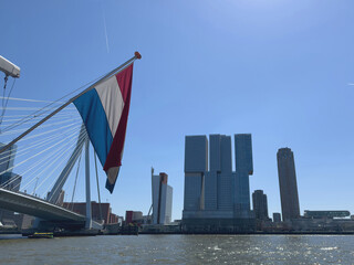 Rotterdam city modern architecture towers and Erasmus bridge, dutch flag waving, Netherlands