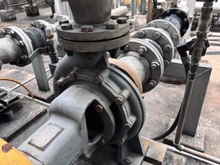 An up-close, detailed view of industrial pipes, pumps, and valves, highlighting the complex network of machinery in a factory or plant setting.