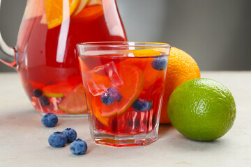 Tasty punch, fruits and berries on light gray table, closeup