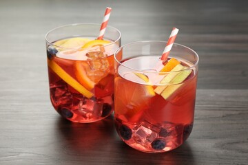 Fruity punch in glasses on wooden table, closeup. Refreshing drink