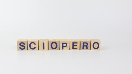 Workers' strike slogan written in Italian on wooden cubes and a white background.