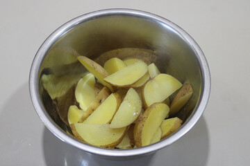 Fresh Raw Potato Wedges in Metal Bowl