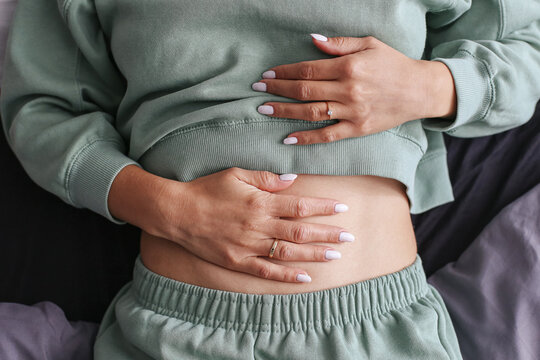 Woman holding stomach. Stomach pain and discomfort. Digestive health problem. Indigestion and bloating. Medical issue with abdomen. Healthcare and lifestyle. Symptoms of poor digestion.